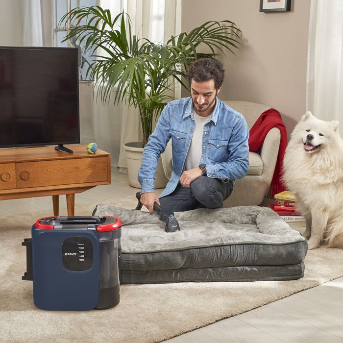 Donna che utilizza StainOver Pet SC40 per pulire un divano beige da macchie